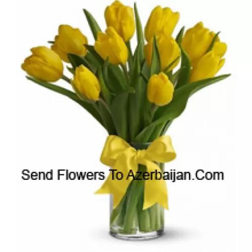 Yellow Tulips With Seasonal Fillers And Leaves In A Glass Vase - Please Note That In Case Of Non-Availability Of Certain Seasonal Flowers The Same Will Be Substituted With Other Flowers Of Same Value